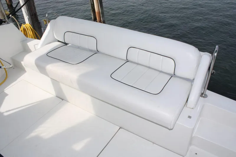 Slide: The Image of White seating on 1995 Carver 380 Santego yacht deck by water. - 8
