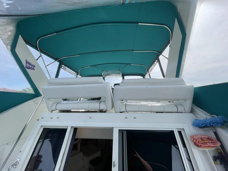Slide: The Image of 1995 Carver 380 Santego yacht with teal canopy and white seating, viewed from the rear. - 10