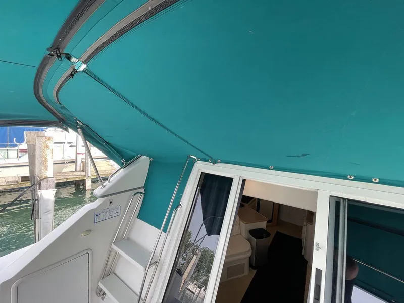 Slide: The Image of 1995 Carver 380 Santego yacht interior with teal canopy and sliding glass doors. - 12