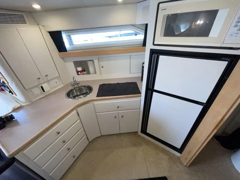Slide: The Image of 1995 Carver 380 Santego yacht kitchen with sink, microwave, and refrigerator. - 36