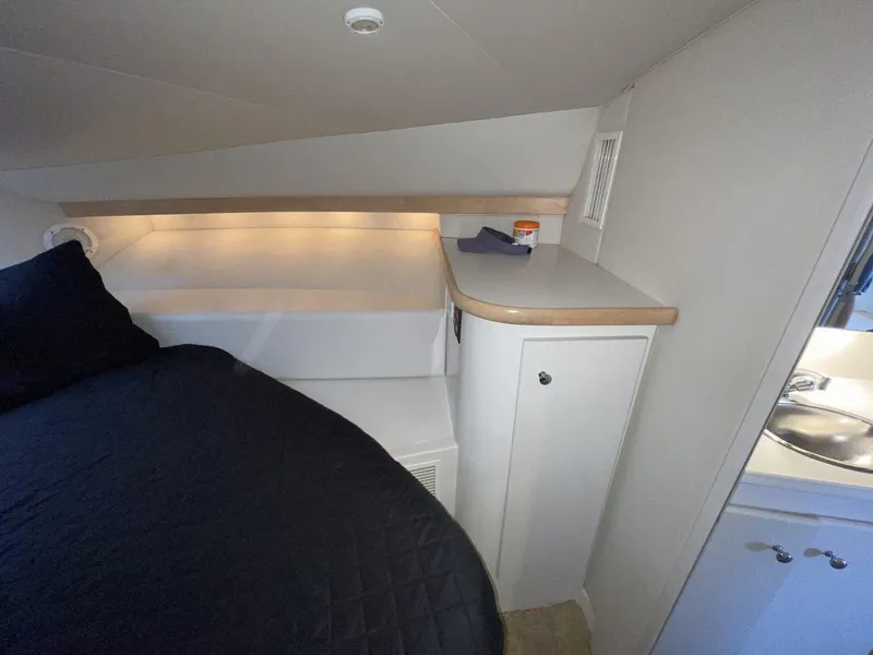 Slide: The Image of 1995 Carver 380 Santego cabin interior with bed, storage, and sink area. - 45