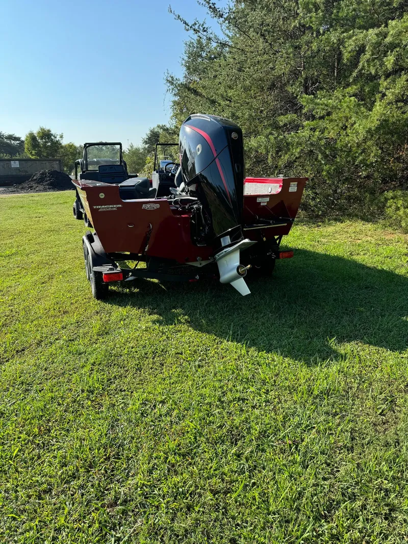 Slide: The Image of 2025 Tracker Targa V-19 Combo boat on grass, rear view, sunny day. - 2