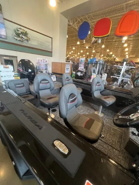 Slide: The Image of 2025 Tracker Targa V-19 Combo boat interior with seating and controls in showroom. - 6