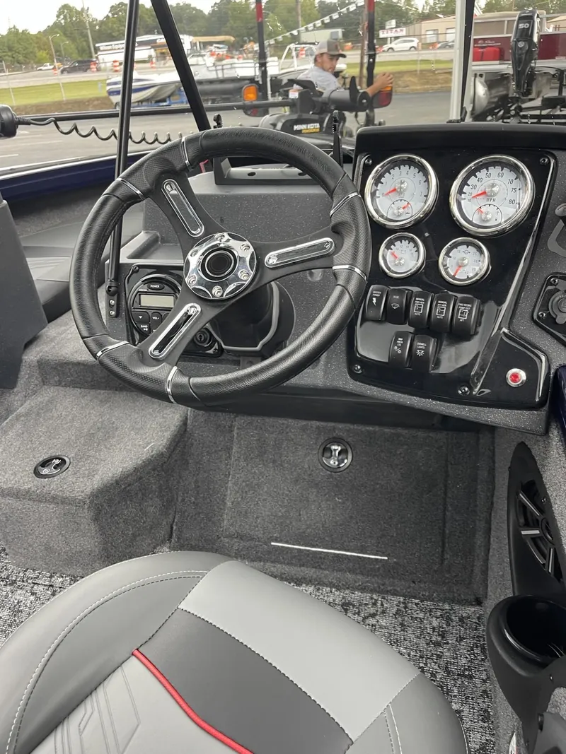 Slide: The Image of 2025 Tracker Targa V-18 Combo boat dashboard with steering wheel and gauges. - 10