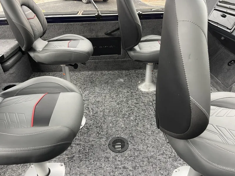 Slide: The Image of 2025 Tracker Targa V-18 Combo boat interior with four gray seats and carpeted floor. - 11