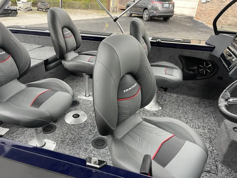 Slide: The Image of 2025 Tracker Targa V-18 Combo boat interior with gray and red seats. - 7