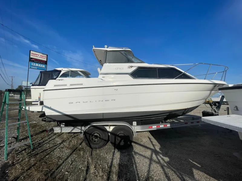 Slide: The Image of 2001 Bayliner 2452 Ciera Express boat on trailer under clear blue sky. - 2