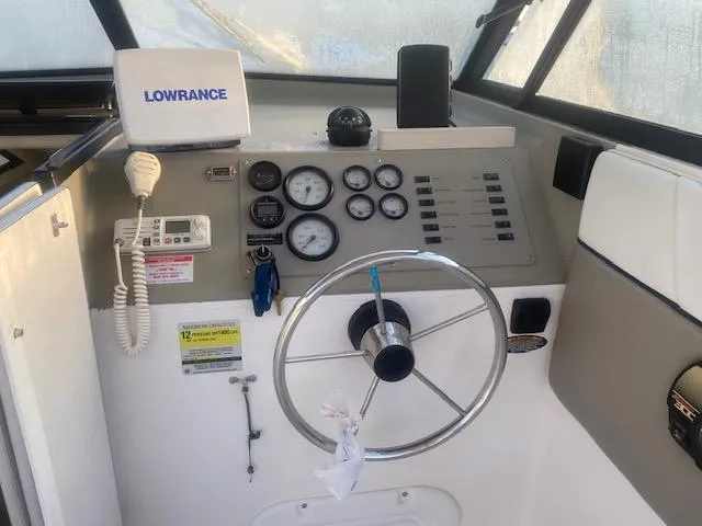 Slide: The Image of 2001 Bayliner 2452 Ciera Express dashboard with steering wheel and navigation instruments. - 4