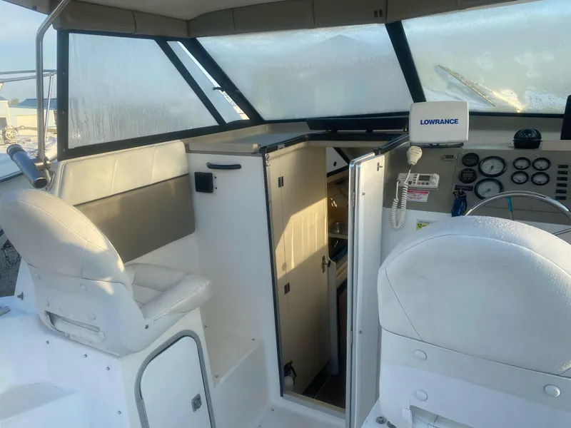 Slide: The Image of 2001 Bayliner 2452 Ciera Express boat interior with helm, seating, and navigation equipment. - 5