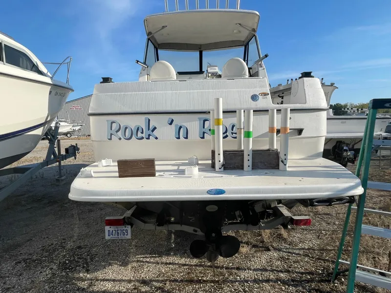 Slide: The Image of 2001 Bayliner 2452 Ciera Express boat on land, rear view with "Rock 'n Reel" text. - 8