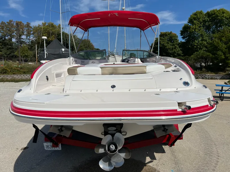 Slide: The Image of 2009 Rinker 246 Captiva Bowrider with red canopy, viewed from the rear. - 10