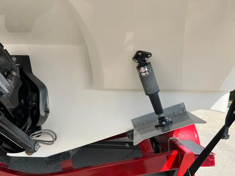 Slide: The Image of 2009 Rinker 246 Captiva Bowrider boat on red trailer, showing trim tab and outdrive. - 15