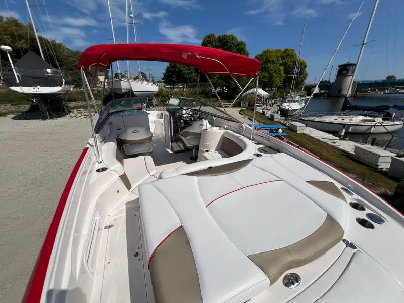 Slide: The Image of 2009 Rinker 246 Captiva Bowrider with red canopy, docked at a marina. - 17