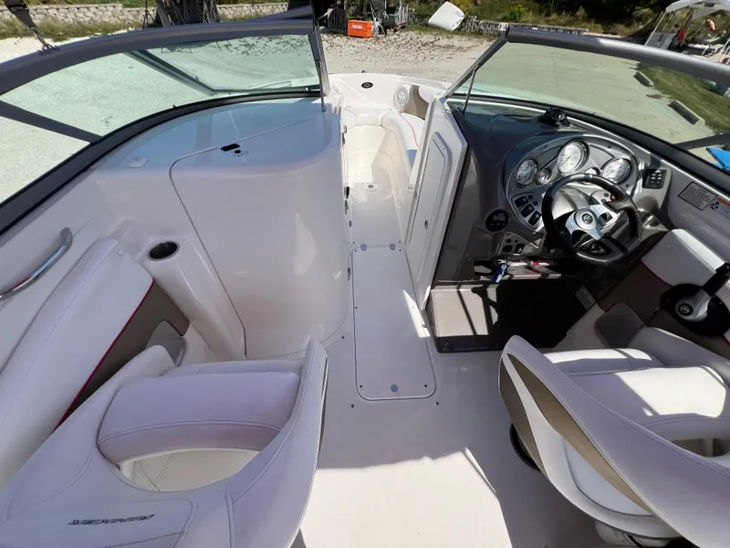 Slide: The Image of 2009 Rinker 246 Captiva Bowrider interior with white seating and modern dashboard controls. - 23