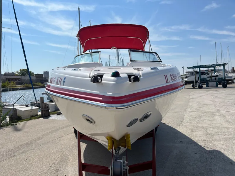 Slide: The Image of 2009 Rinker 246 Captiva Bowrider with red canopy on a docked trailer. - 3