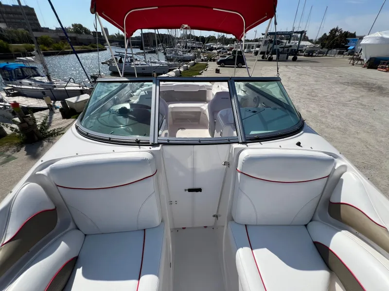 Slide: The Image of 2009 Rinker 246 Captiva Bowrider with red canopy, docked at marina. - 30