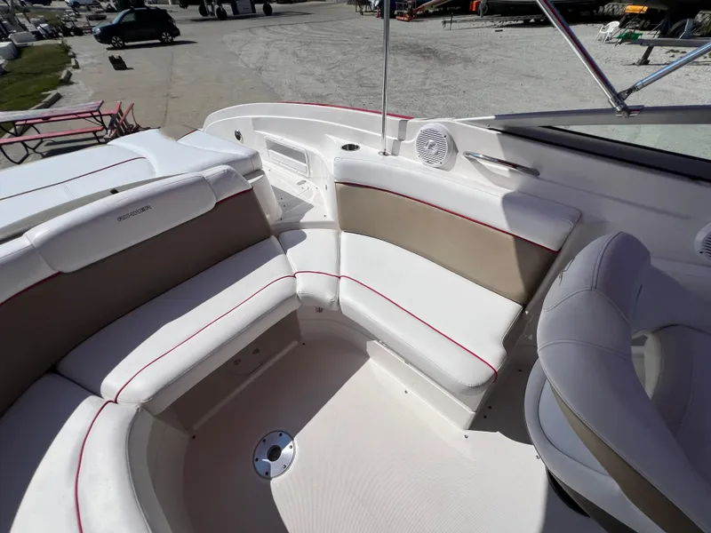 Slide: The Image of 2009 Rinker 246 Captiva Bowrider interior with white and beige seating, outdoor setting. - 33
