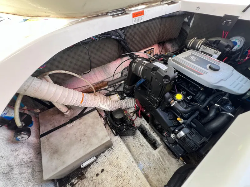Slide: The Image of Engine compartment of a 2009 Rinker 246 Captiva Bowrider, showcasing mechanical components and wiring. - 35