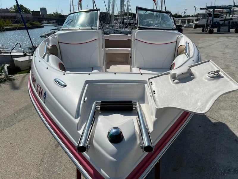 Slide: The Image of 2009 Rinker 246 Captiva Bowrider boat docked, featuring open bow seating and sleek design. - 4