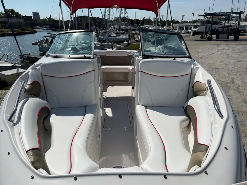 Slide: The Image of 2009 Rinker 246 Captiva Bowrider with white and red interior, docked at marina. - 5