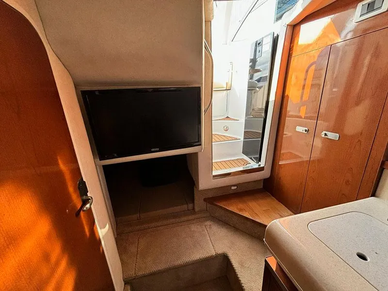 Slide: The Image of Interior of 2012 Sea Ray 260 Sundancer with TV, wooden cabinetry, and steps to deck. - 10