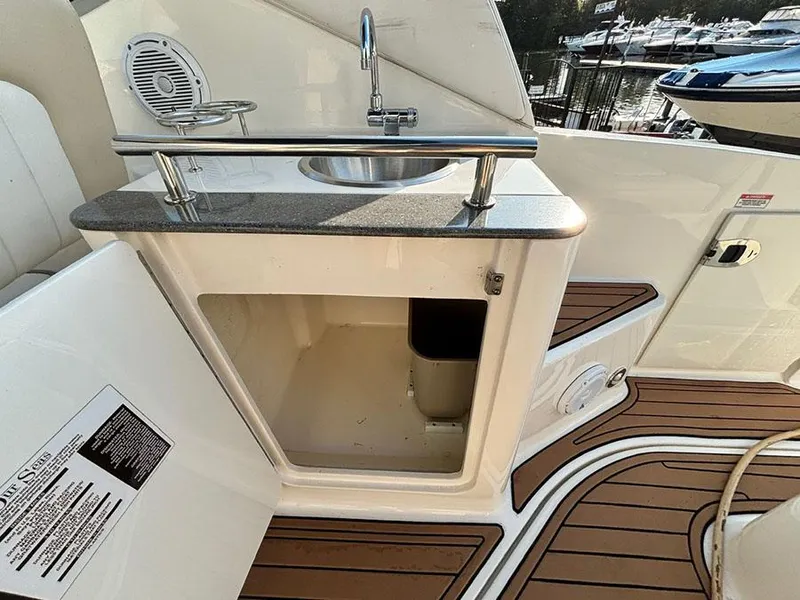 Slide: The Image of 2012 Sea Ray 260 Sundancer boat interior with sink and storage area. - 14