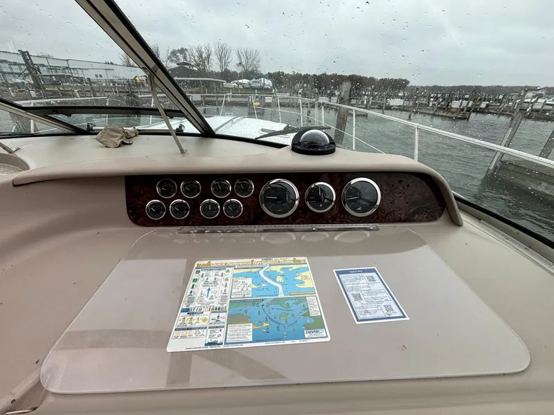 Slide: The Image of 1998 Sea Ray 400 Sundancer dashboard with gauges and navigation map, docked by the water. - 11