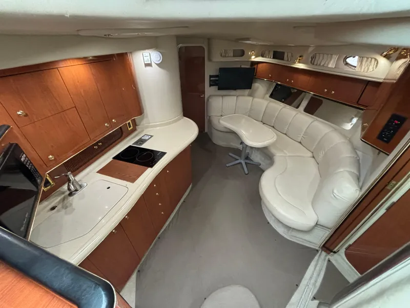 Slide: The Image of 1998 Sea Ray 400 Sundancer interior with kitchen and curved seating area. - 12