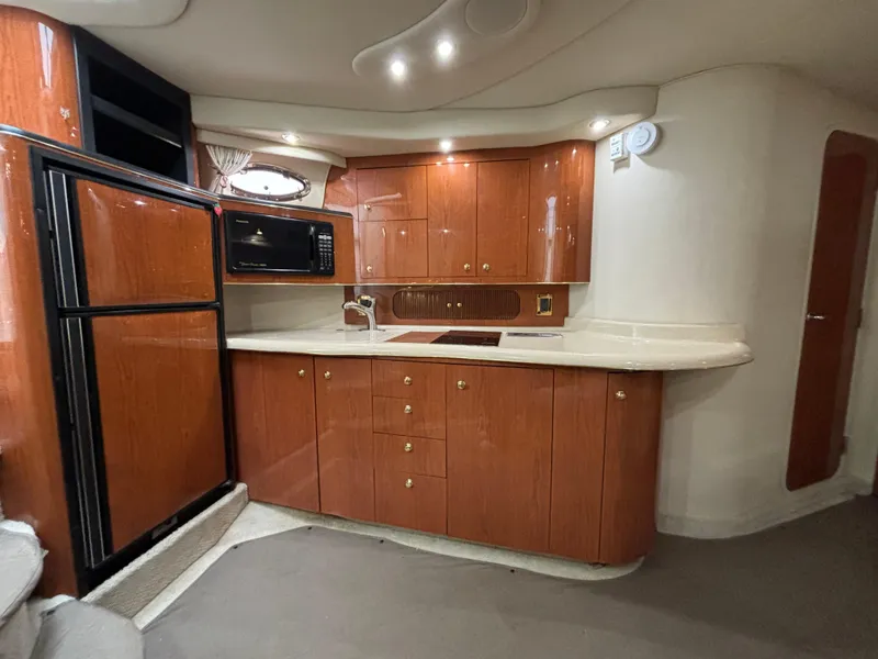 Slide: The Image of 1998 Sea Ray 400 Sundancer yacht kitchen with wood cabinets and modern appliances. - 14