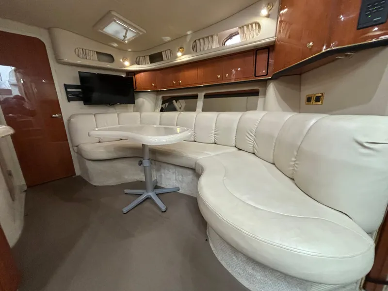 Slide: The Image of Interior of 1998 Sea Ray 400 Sundancer yacht with plush seating and mounted TV. - 15