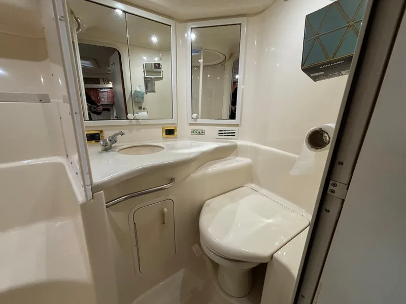 Slide: The Image of 1998 Sea Ray 400 Sundancer bathroom with sink, toilet, and mirrored cabinet. - 17