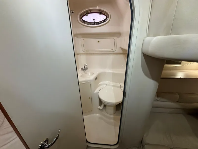 Slide: The Image of 1998 Sea Ray 400 Sundancer bathroom with compact design and porthole window. - 18