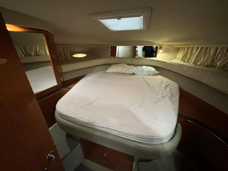 Slide: The Image of 1998 Sea Ray 400 Sundancer cabin interior with bed, wooden accents, and soft lighting. - 20