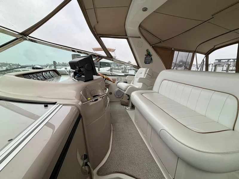 Slide: The Image of 1998 Sea Ray 400 Sundancer yacht interior with beige seating and helm station. - 8