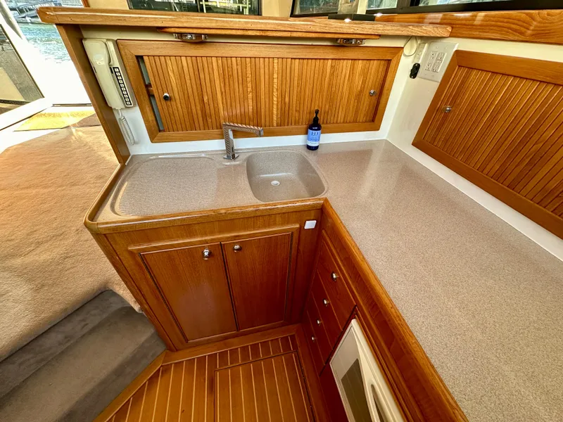 Slide: The Image of 1998 Riviera 43 yacht kitchen with wooden cabinets, sink, and countertop. - 18