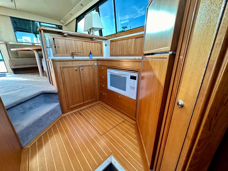 Slide: The Image of Interior of 1998 Riviera 43 yacht with wooden cabinetry and modern appliances. - 19