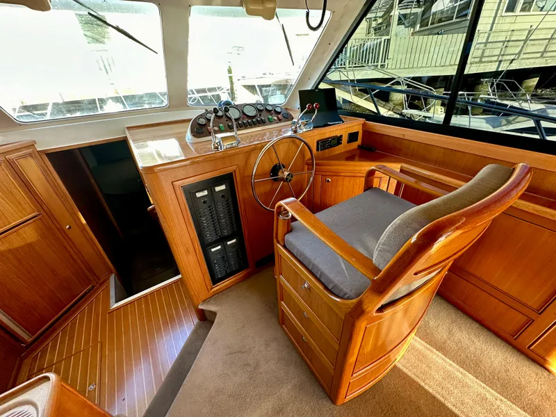 Slide: The Image of 1998 Riviera 43 yacht helm with wooden interior and steering wheel. - 20