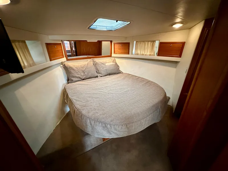 Slide: The Image of Cozy bedroom in 1998 Riviera 43 yacht with skylight and wooden accents. - 25
