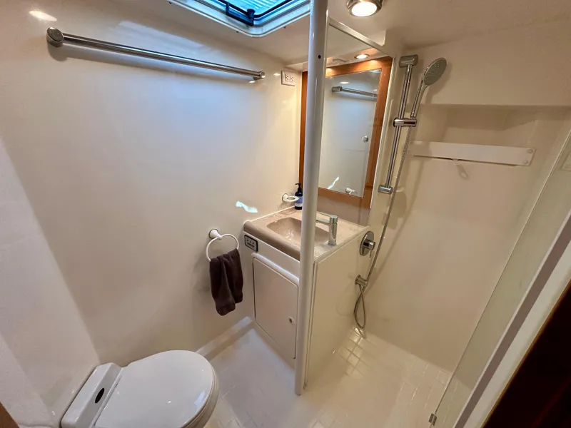 Slide: The Image of 1998 Riviera 43 yacht bathroom with shower, sink, and toilet. Bright and compact design. - 28