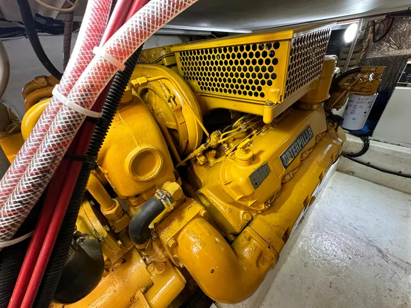 Slide: The Image of Engine room of a 1998 Riviera 43 yacht, featuring a yellow Caterpillar engine. - 36