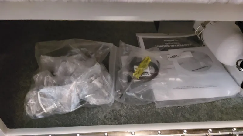 Slide: The Image of Boat storage compartment with manuals and parts for 2025 Formula 330 Crossover Bowrider OB. - 32