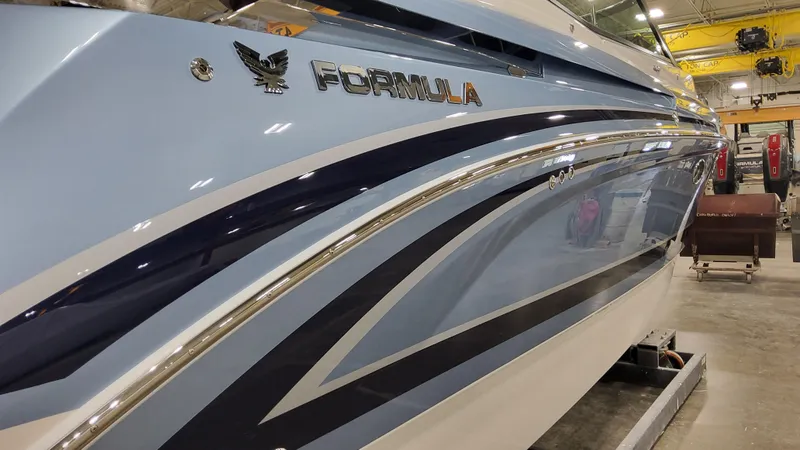 Slide: The Image of 2025 Formula 330 Crossover Bowrider OB in a showroom, showcasing sleek design and branding. - 5