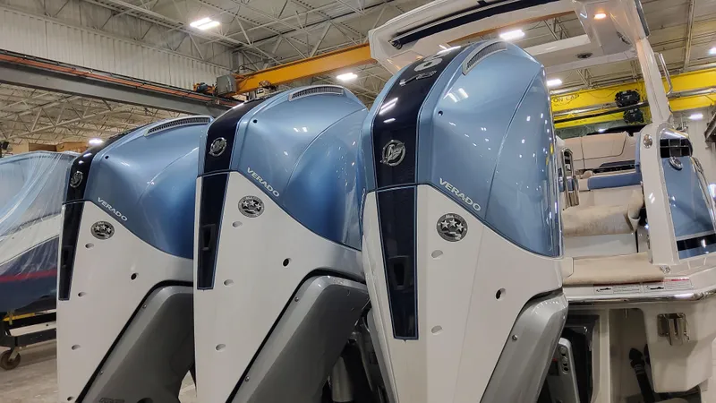 Slide: The Image of 2025 Formula 330 Crossover Bowrider OB with triple outboard engines in a showroom. - 7