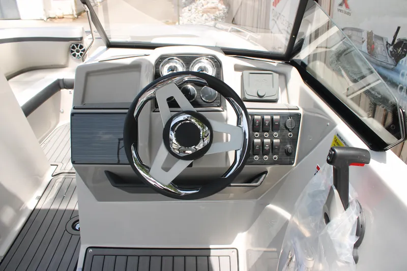 Slide: The Image of 2025 Starcraft 230 boat dashboard with steering wheel and control panel. - 12