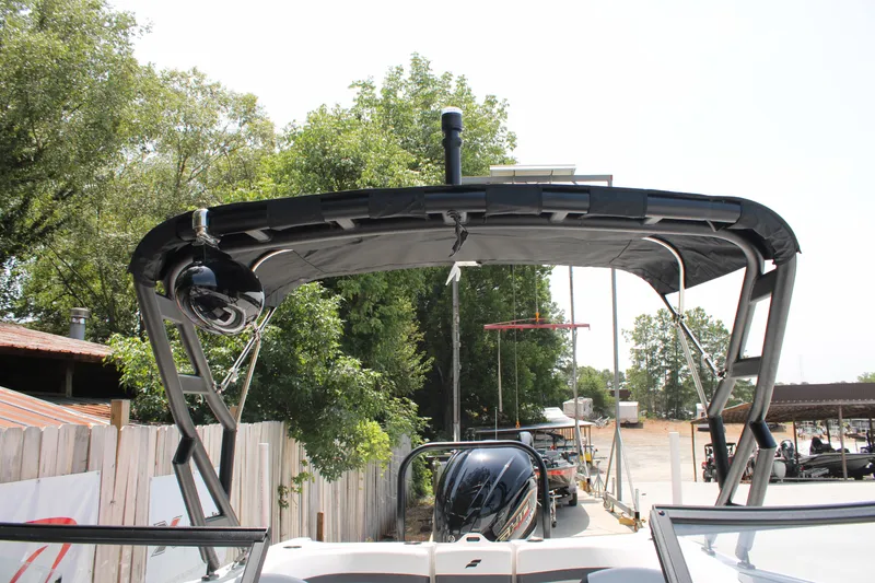 Slide: The Image of 2025 Starcraft 230 boat with canopy, parked outdoors near trees and buildings. - 19