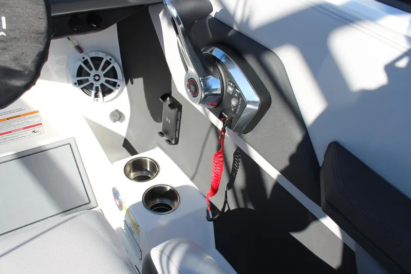 Slide: The Image of 2025 Cobalt CS23 boat interior with control panel and cup holders. - 23
