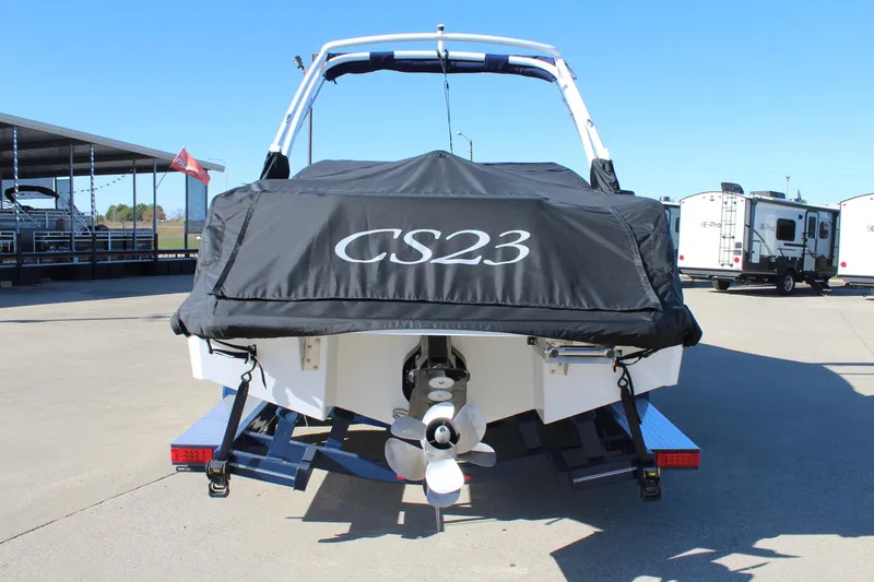 Slide: The Image of 2025 Cobalt CS23 boat with cover, parked on trailer in sunny marina. - 7