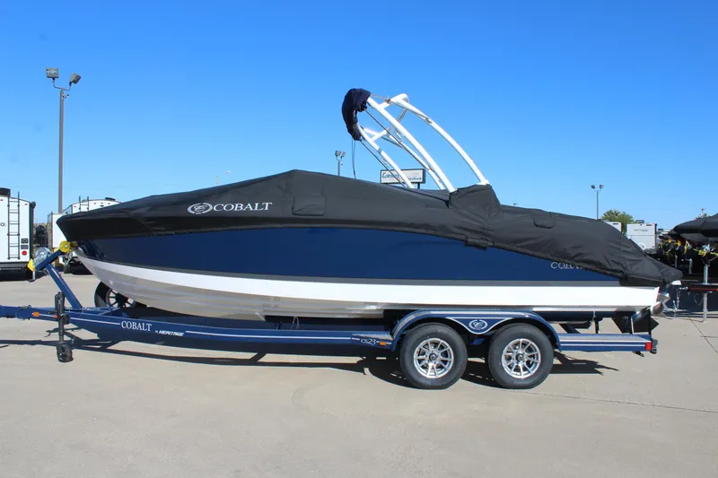 Slide: The Image of 2025 Cobalt CS23 boat on trailer with cover, parked outdoors. - 8