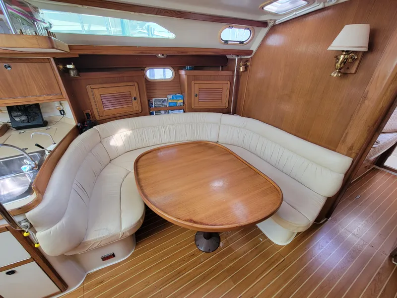 Slide: The Image of Interior of 2003 Catalina 42 Mk2 sailboat with wooden dining area and plush seating. - 4