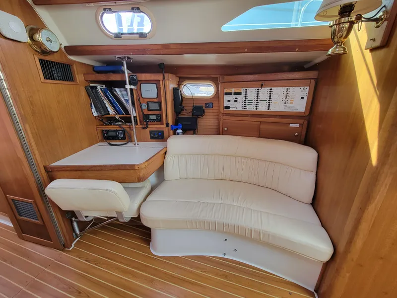 Slide: The Image of Interior of 2003 Catalina 42 Mk2 sailboat with navigation station and curved seating. - 5